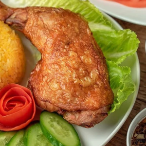 Cơm gà xối mỡ là món ăn hấp dẫn với hương vị đậm đà và vẻ ngoài bắt mắt. Phần cơm vàng óng, tơi xốp, được nấu từ nước luộc gà nên thơm và béo nhẹ. Điểm nổi bật nhất là miếng gà chiên giòn, lớp da vàng rụm, thịt bên trong mềm ngọt, giữ được độ mọng nước. Khi ăn, lớp da giòn tan kết hợp với cơm nóng tạo nên sự hòa quyện hoàn hảo. Món ăn thường được dùng kèm dưa leo, cà chua và rau sống để tăng độ tươi mát, cân bằng vị béo. Nước chấm chua ngọt hoặc xì dầu giúp món ăn thêm phần đậm đà. Không chỉ ngon, cơm gà xối mỡ còn cung cấp nhiều năng lượng, phù hợp cho bữa ăn no lâu. Đây là lựa chọn quen thuộc, được nhiều người yêu thích.