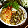 Cơm rang dưa bò là món ăn dân dã nhưng đậm đà, hấp dẫn bởi sự kết hợp hài hòa giữa cơm, dưa chua và thịt bò. Hạt cơm vàng tơi, săn chắc, được rang đều tay, quyện cùng vị chua nhẹ của dưa cải tạo nên hương vị rất riêng. Thịt bò mềm, ngọt tự nhiên, được xào nhanh trên lửa lớn nên vẫn giữ được độ mọng và không bị dai. Khi ăn, vị chua thanh của dưa giúp cân bằng độ béo của cơm, khiến món ăn không bị ngấy mà còn kích thích vị giác. Món ăn thường được thêm hành lá hoặc tiêu để tăng hương thơm. Không chỉ ngon, cơm rang dưa bò còn cung cấp đủ dinh dưỡng với tinh bột, protein và chất xơ. Đây là lựa chọn quen thuộc cho bữa ăn nhanh gọn nhưng vẫn đậm vị và dễ ăn.