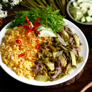 Cơm rang dưa bò là món ăn dân dã nhưng đậm đà, hấp dẫn bởi sự kết hợp hài hòa giữa cơm, dưa chua và thịt bò. Hạt cơm vàng tơi, săn chắc, được rang đều tay, quyện cùng vị chua nhẹ của dưa cải tạo nên hương vị rất riêng. Thịt bò mềm, ngọt tự nhiên, được xào nhanh trên lửa lớn nên vẫn giữ được độ mọng và không bị dai. Khi ăn, vị chua thanh của dưa giúp cân bằng độ béo của cơm, khiến món ăn không bị ngấy mà còn kích thích vị giác. Món ăn thường được thêm hành lá hoặc tiêu để tăng hương thơm. Không chỉ ngon, cơm rang dưa bò còn cung cấp đủ dinh dưỡng với tinh bột, protein và chất xơ. Đây là lựa chọn quen thuộc cho bữa ăn nhanh gọn nhưng vẫn đậm vị và dễ ăn.